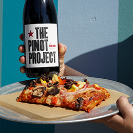 Milo SRO's bottle of wine and gluten-free pizza slice photo credit Lindsey Huttrer