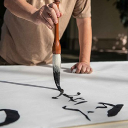 Calligraphy artist Tang Qingnian at work on a large scroll during a public demonstration in 2018_photo by Jaime Pham
