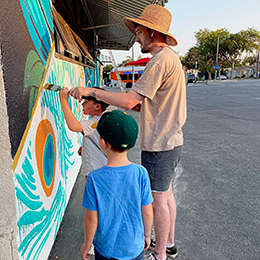 Artist Ian Schuler working on the mural at Porticos Art Space with his son_photo courtesy Arroyo Repertory Theatre